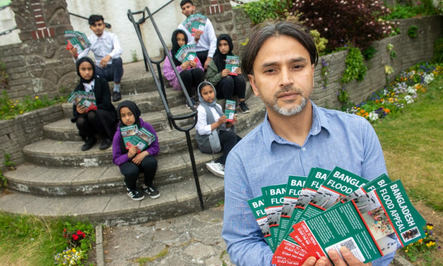 Adbul Hamid and family on the steps outside Carron to Mumbai restaurant